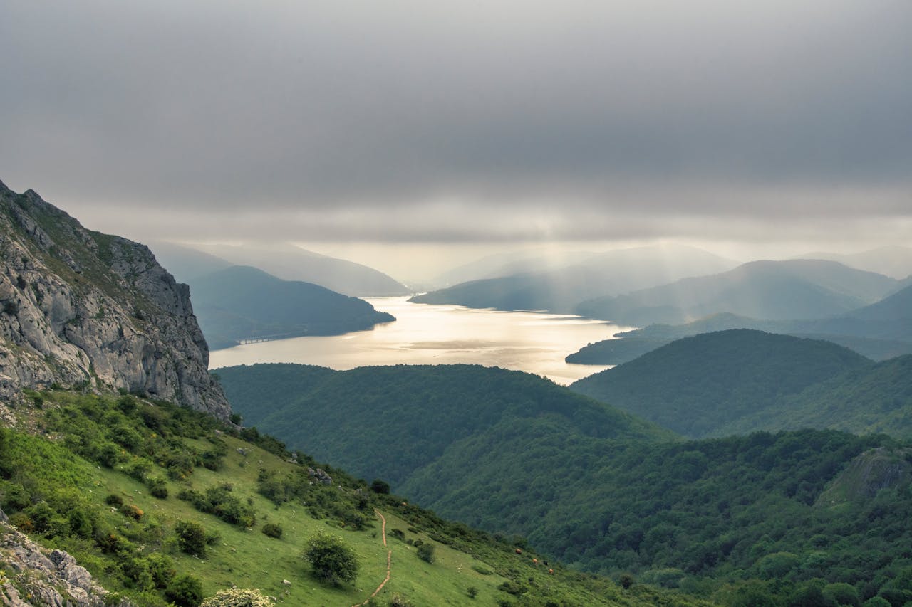 Breathtaking mountain and lake view in Riaño, Spain, under dramatic cloud cover.